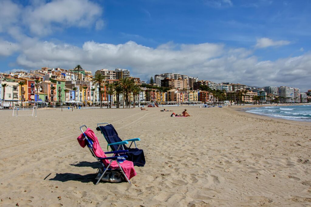 Вильяхойоса.Пляж Вильяхойосы с пустыми лежаками и ярким небом на побережье Коста-Бланка