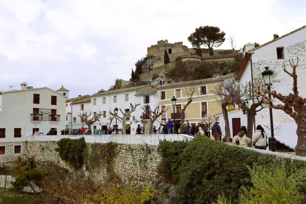 Центральная площадь города Гуадалест с белыми домами и крепостью на скале, провинция Аликанте, Испания