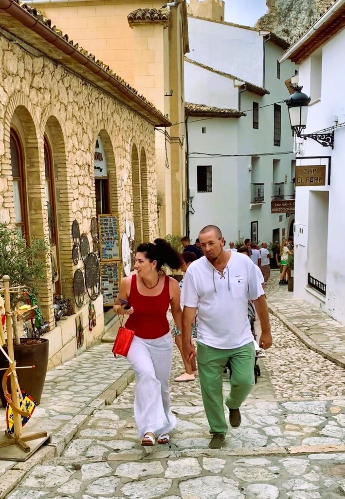 Туристы гуляют по мощёной улице в старом городе Гуадалест, Аликанте, Испания